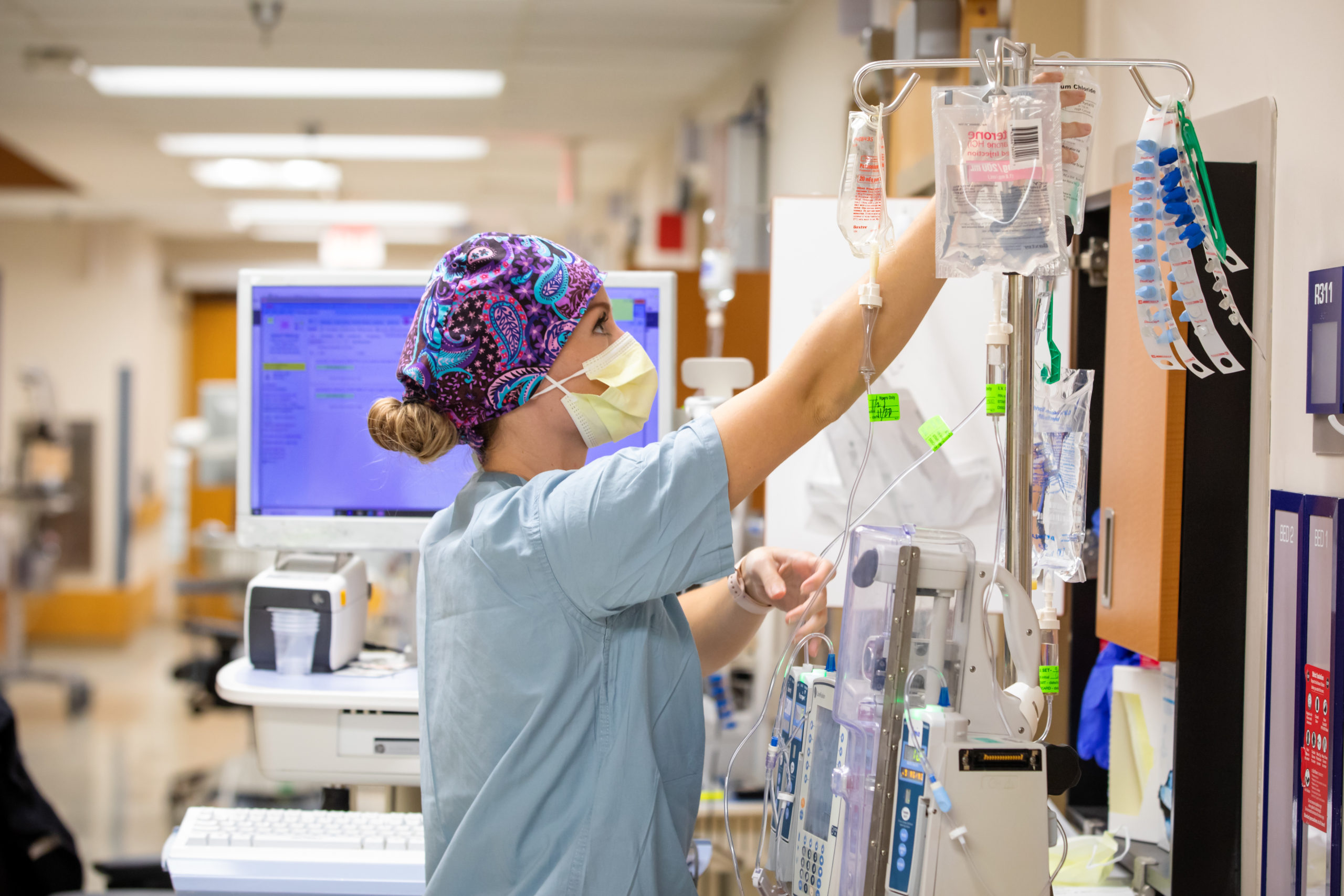 Nurse Kristian Adair manages IV pumps outside a COVID patient’s room in the 3r COVID ICU at Tampa General Hospital on Nov. 23, 2020.